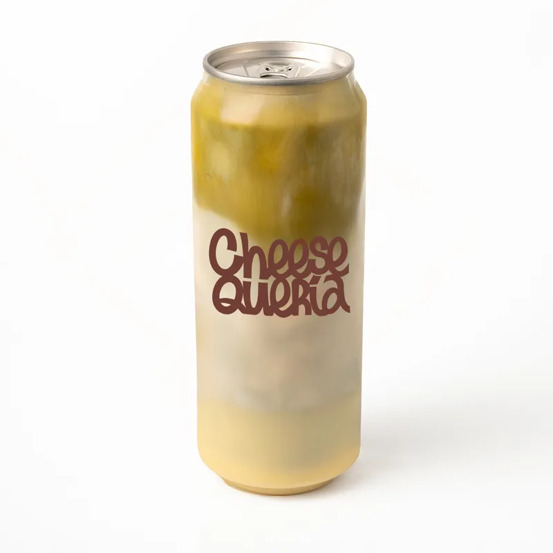 Matcha choco blanco: matcha, leche de avena y chocolate blanco en el fondo, en lata transparente con el logo de Cheesequería