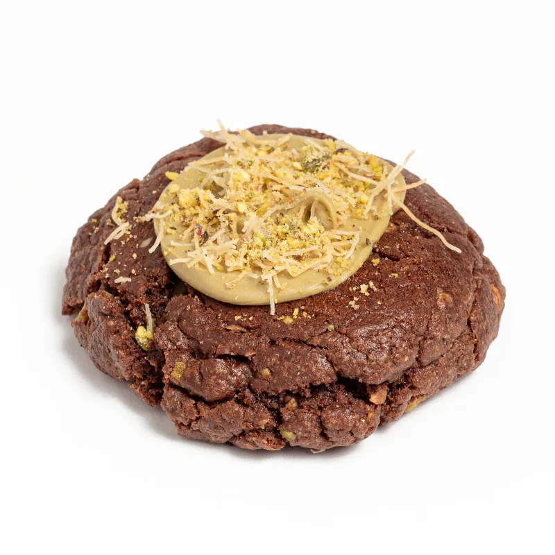 Cookie de cacao con crema de pistacho, pistacho picado y hebras crujientes por encima
