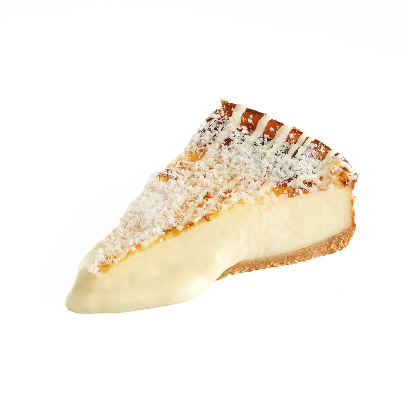 Porción de tarta de queso de Raffaello con coco rallado e hilos de chocolate blanco