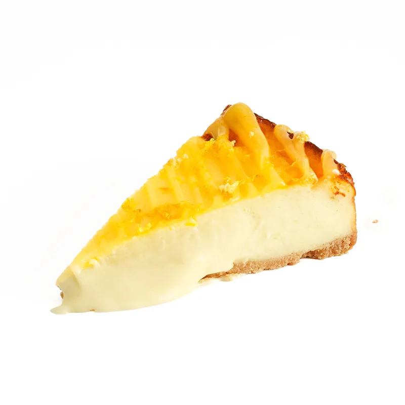Porción de tarta de queso de galleta y limón con cobertura amarilla y ralladura por encima