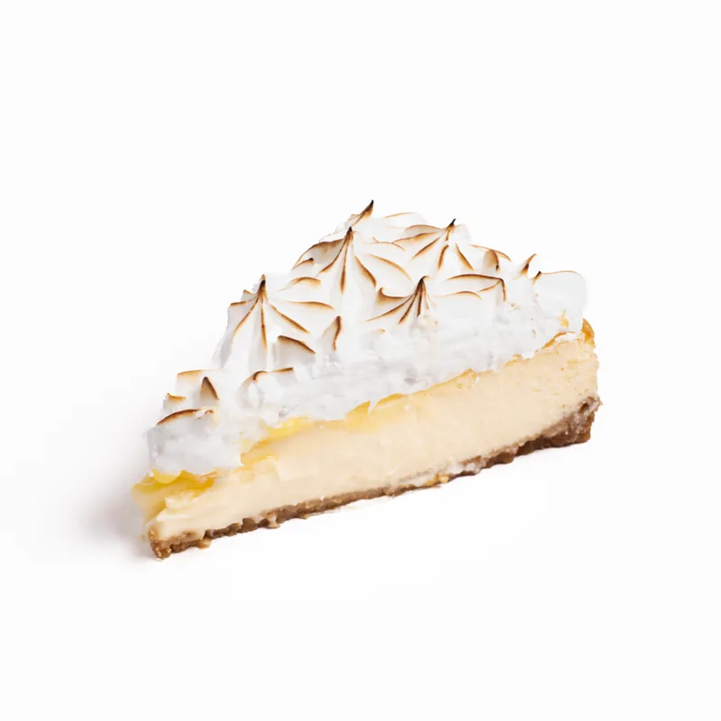 Porción de tarta de queso lemon pie con merengue tostado y una fina capa de limón sobre la base de galleta