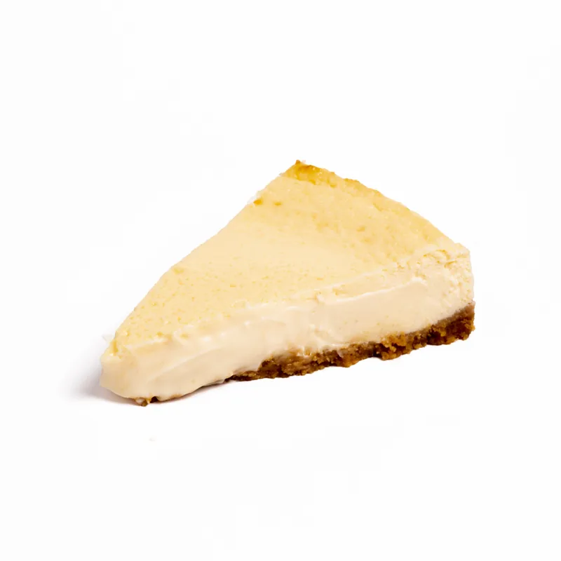 Porción de tarta de queso tradicional de interior cremoso sobre base de galleta